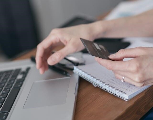 کاربری در حال استفاده از لپ تاپ و ویزا کارت برای خرید آنلاین