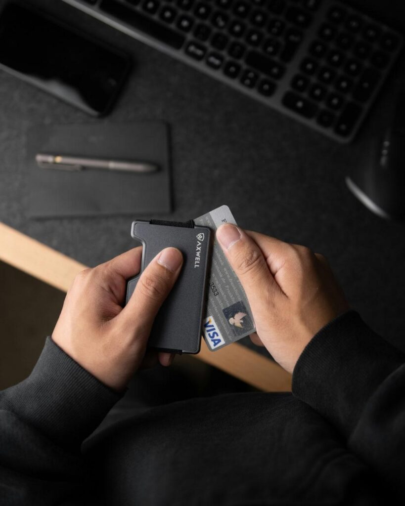 شخصی در حال قرار دادن یک کارت ویزا در یک کیف مشکی