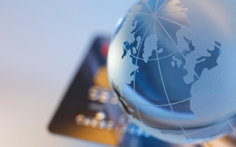 تصویر ویزا کارت در کنار کره زمین برای پرداخت های جهانی